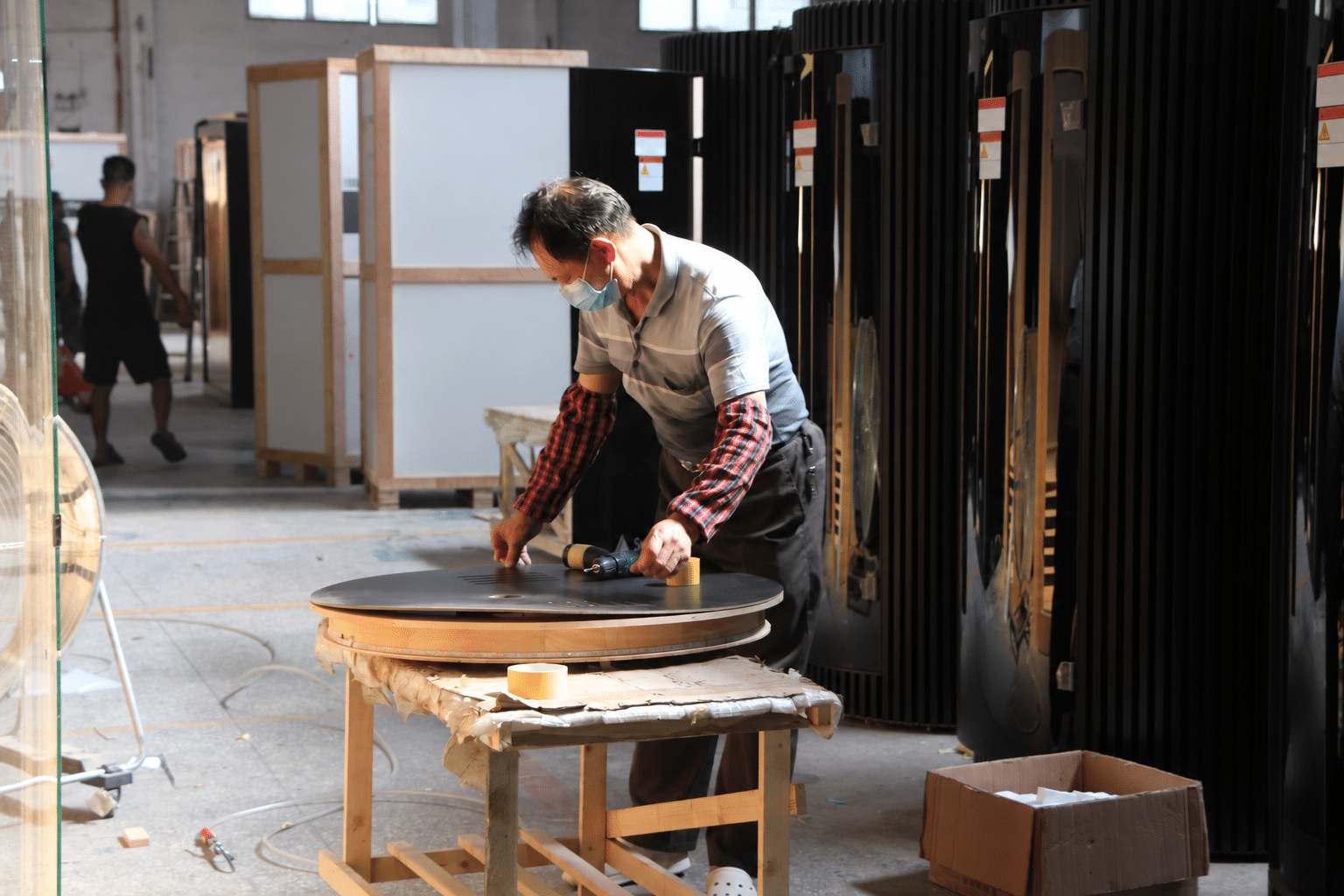 Bropool worker assembling a rounded black sauna panel in the factory