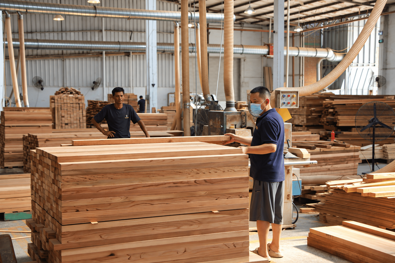 Bropool employees preparing stacked timber boards for sauna production